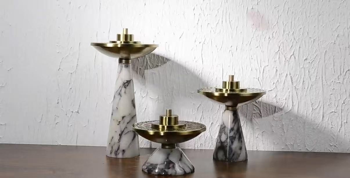 Three Marble & Metal Incense Burners in brushed gold on a walnut table